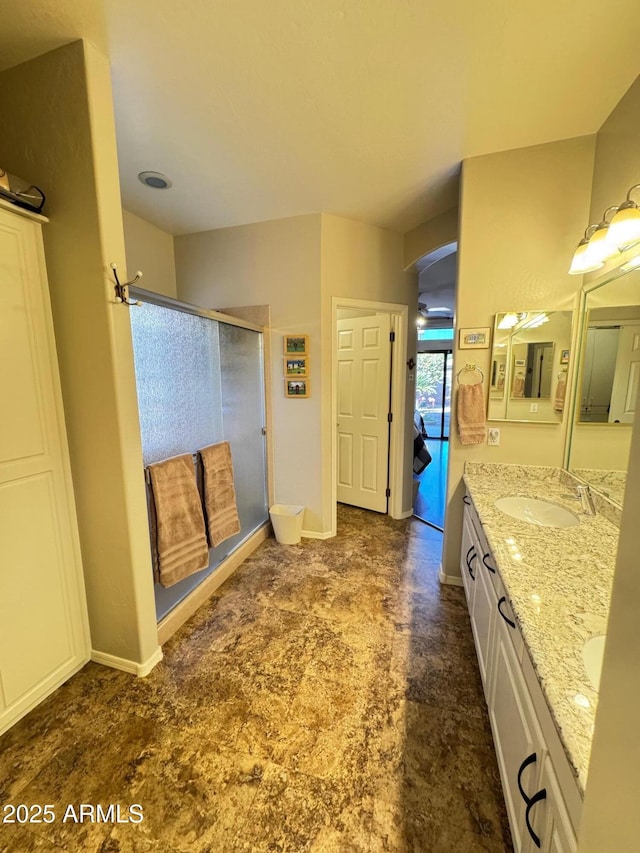 bathroom featuring vanity and a shower with door