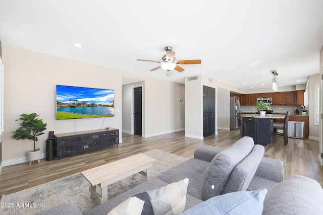 living room with dark wood-type flooring and ceiling fan