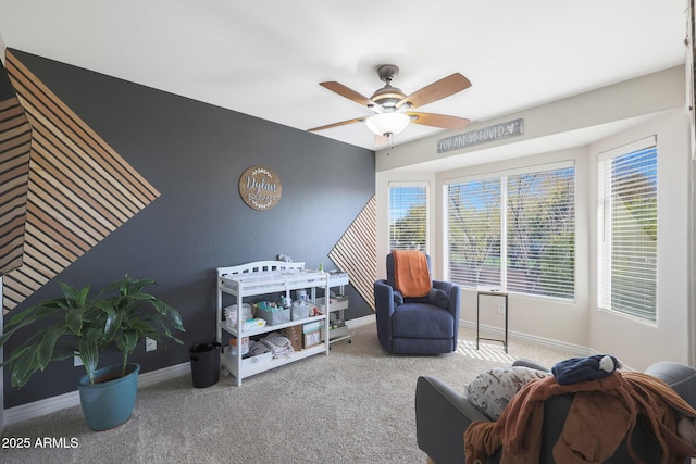 sitting room with ceiling fan and carpet