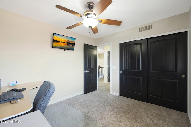 carpeted home office featuring ceiling fan