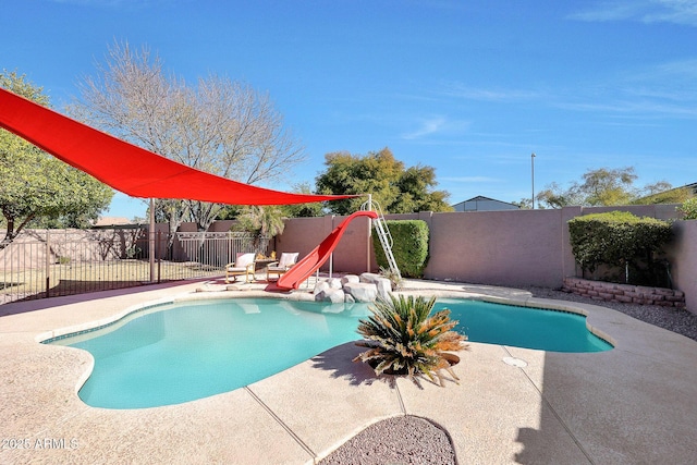 view of pool with a water slide and a patio area