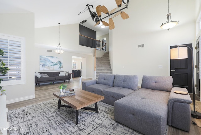 living room featuring wood-type flooring and high vaulted ceiling