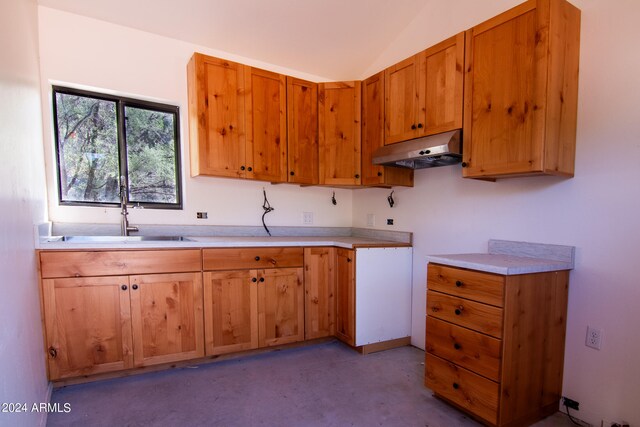 kitchen featuring lofted ceiling and sink