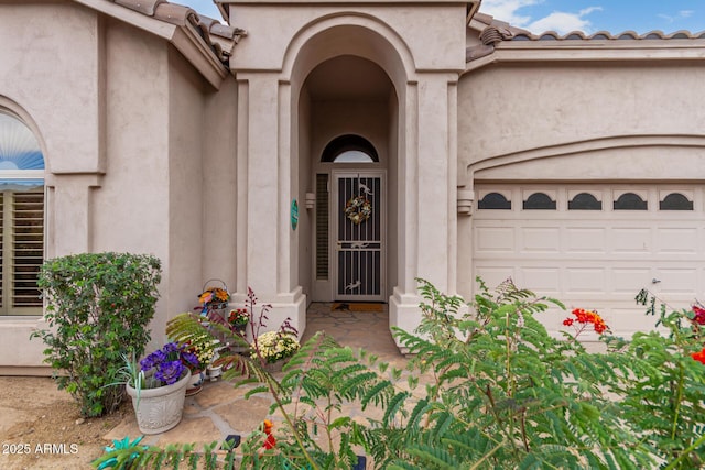 3055 N Red Mtn Unit 77, Mesa, AZ 85207 - view of exterior entry with stucco siding, a garage, and a tile roof