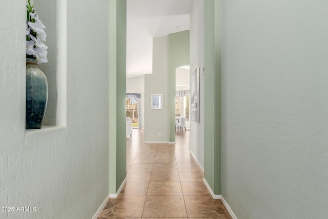 3055 N Red Mtn Unit 77, Mesa, AZ 85207 - hall with tile patterned floors, arched walkways, a textured wall, and baseboards