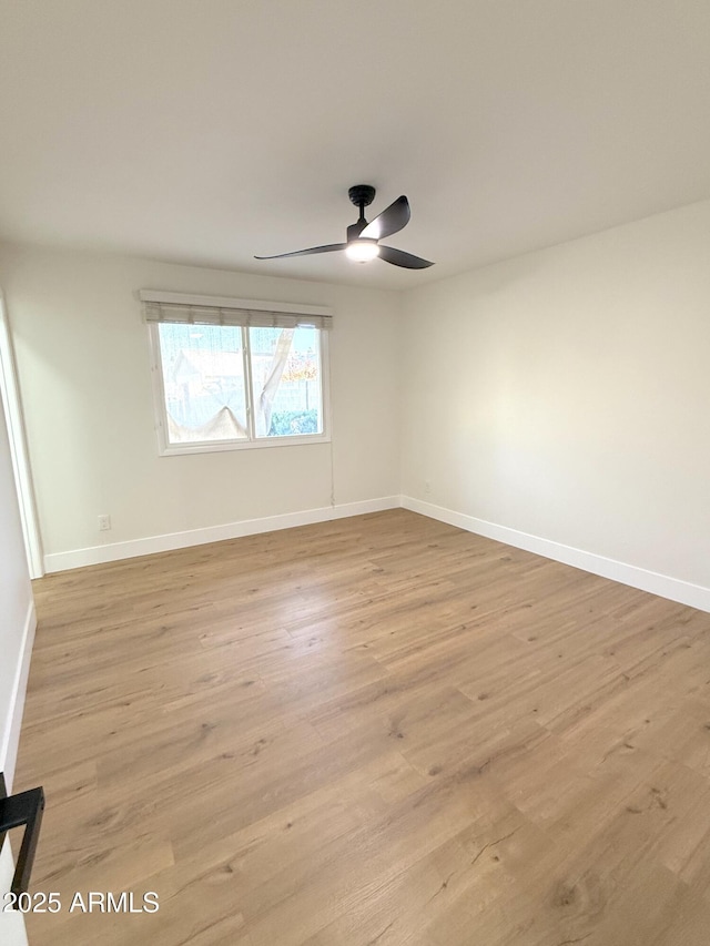 empty room with ceiling fan and light hardwood / wood-style floors