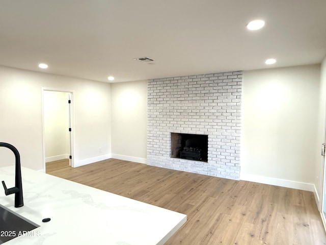 unfurnished living room featuring a fireplace and wood-type flooring