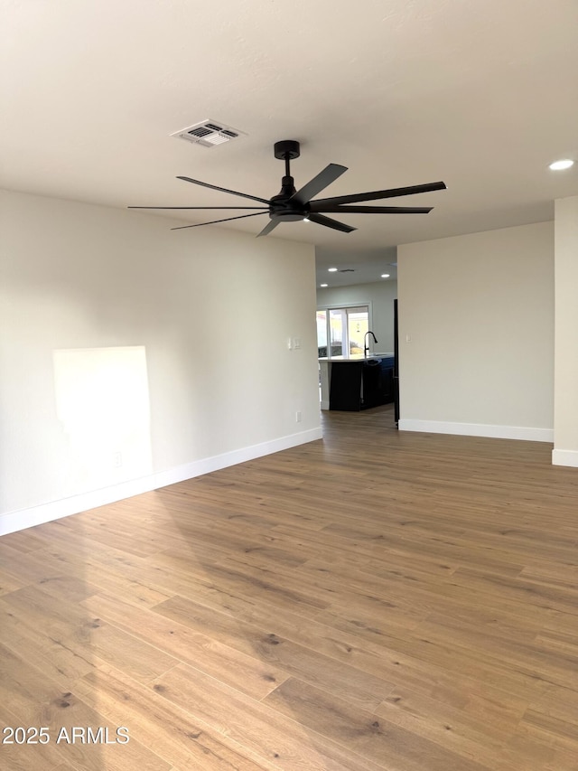 empty room featuring ceiling fan and light wood-type flooring