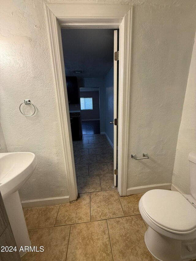 bathroom featuring tile patterned flooring, toilet, and sink