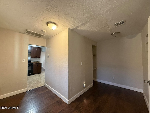 corridor with hardwood / wood-style floors and a textured ceiling