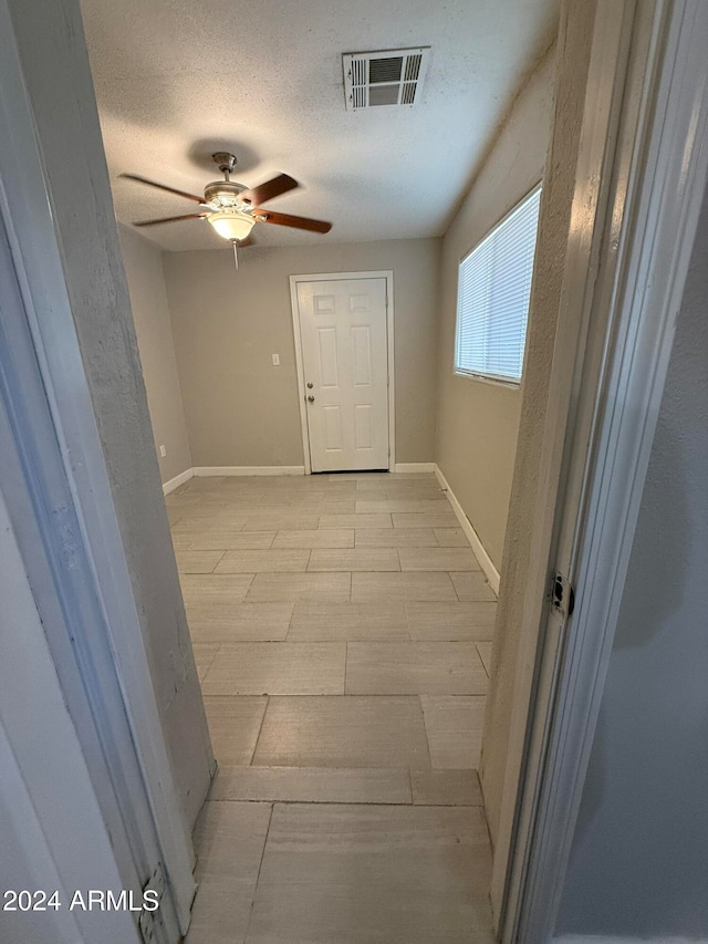 hall featuring a textured ceiling