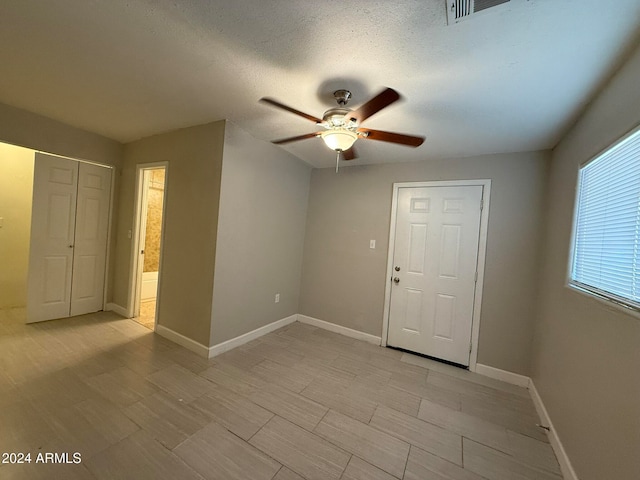 unfurnished room featuring ceiling fan and a textured ceiling