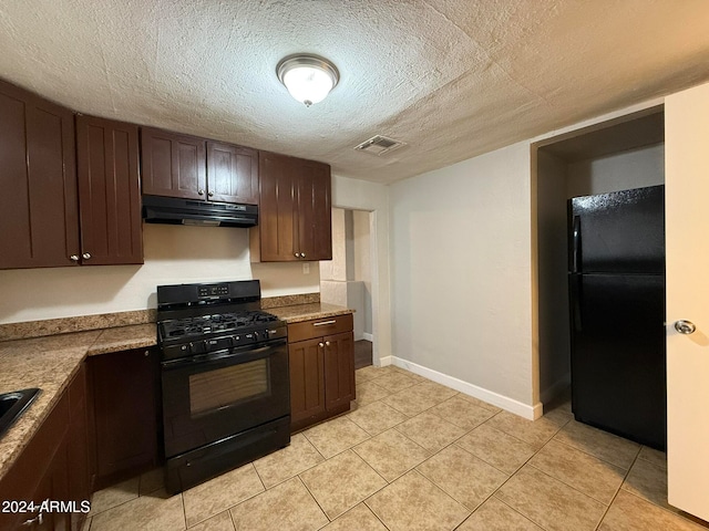 kitchen featuring black appliances, light tile patterned flooring, dark brown cabinetry, and a textured ceiling