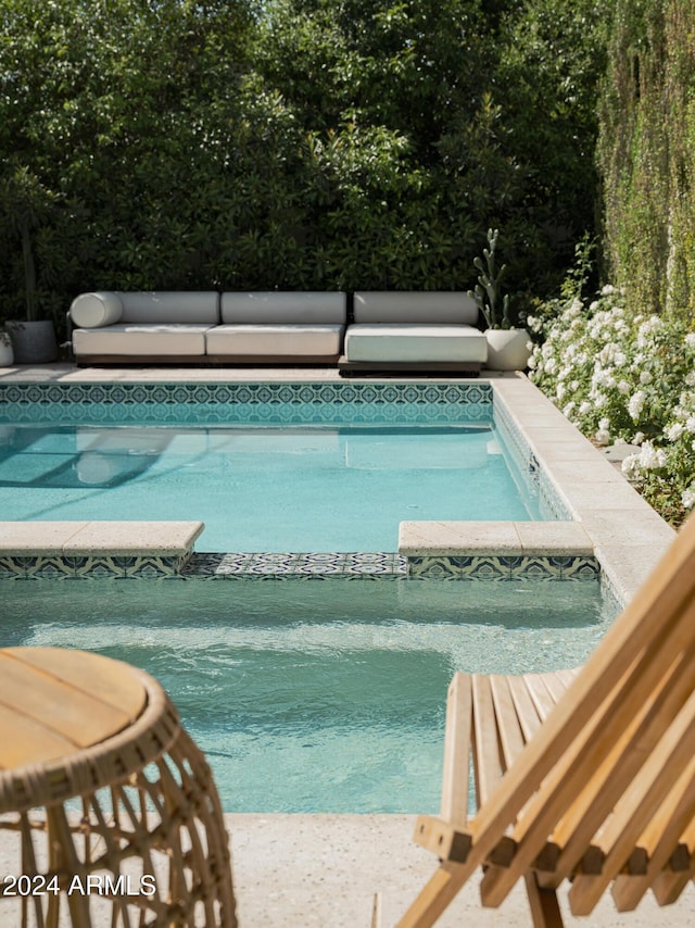 view of swimming pool with an in ground hot tub