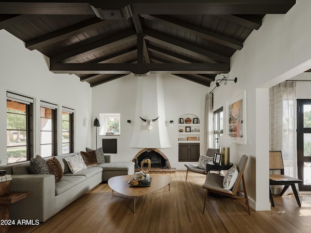 living room with hardwood / wood-style flooring, a fireplace, high vaulted ceiling, and beamed ceiling