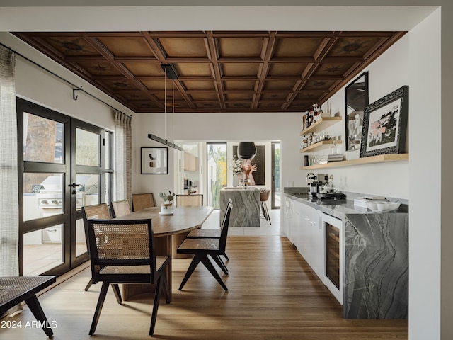 dining room with wood-type flooring, beverage cooler, and french doors