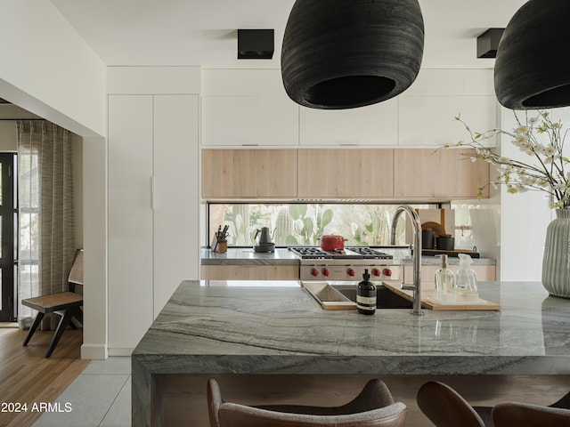 kitchen featuring light stone counters, light brown cabinetry, light tile patterned floors, and plenty of natural light