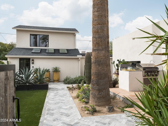 rear view of property featuring an outdoor kitchen