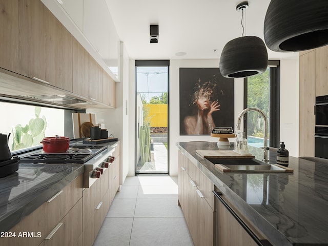 kitchen with a healthy amount of sunlight, sink, hanging light fixtures, and light tile patterned floors