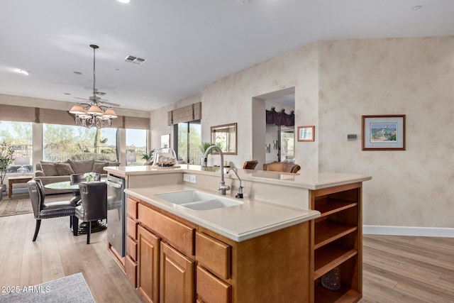 kitchen with stainless steel dishwasher, sink, a center island with sink, and light wood-type flooring