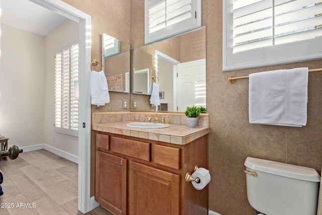 bathroom featuring wood-type flooring, toilet, and vanity