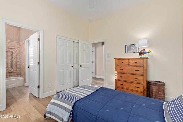 bedroom with connected bathroom, light hardwood / wood-style floors, a closet, and ceiling fan