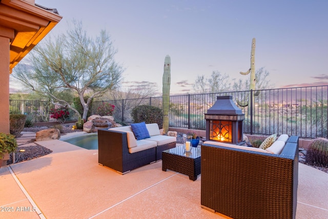 patio terrace at dusk with an outdoor living space with a fireplace