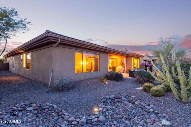 back house at dusk with a patio area