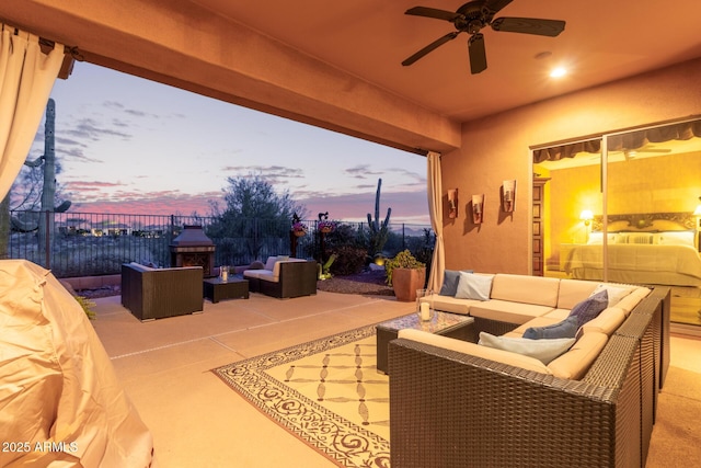 patio terrace at dusk with an outdoor living space and ceiling fan