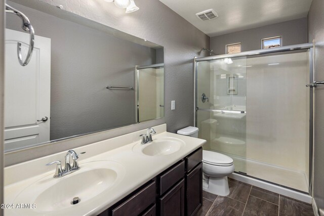 full bathroom featuring visible vents, a stall shower, toilet, and a sink