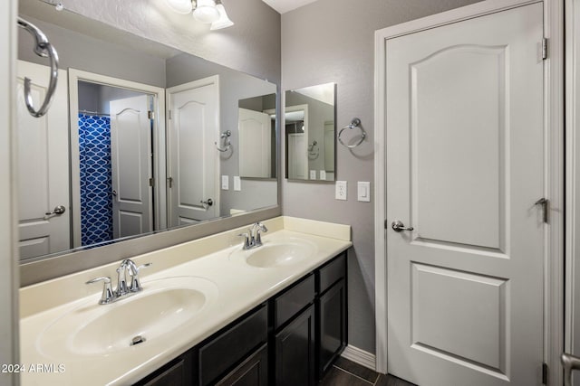 bathroom featuring double vanity and baseboards