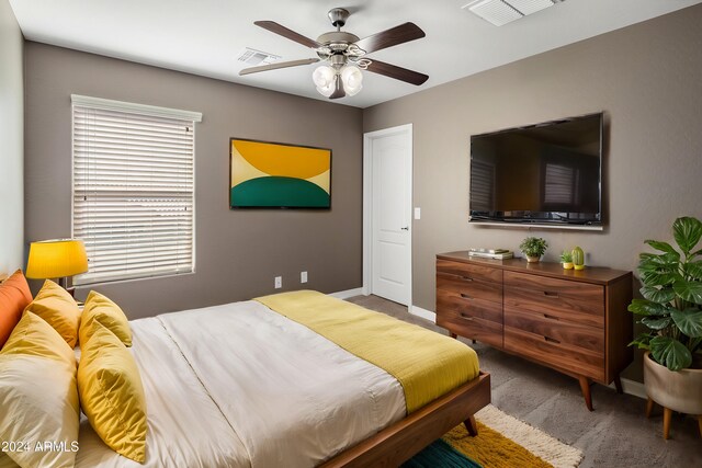 carpeted bedroom with visible vents, baseboards, and a ceiling fan