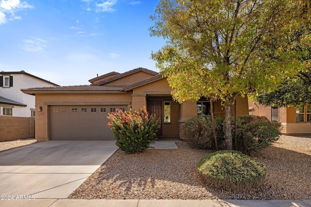 ranch-style home with stucco siding, a garage, driveway, and fence