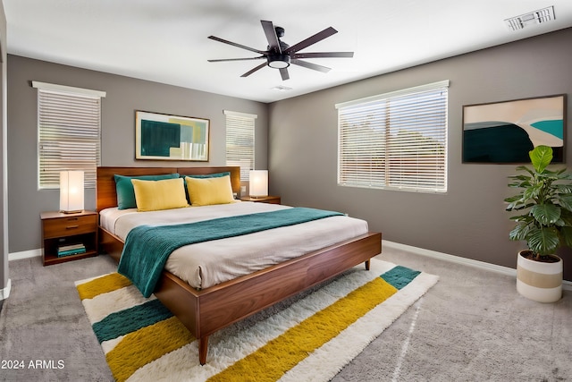 carpeted bedroom featuring baseboards, visible vents, and ceiling fan