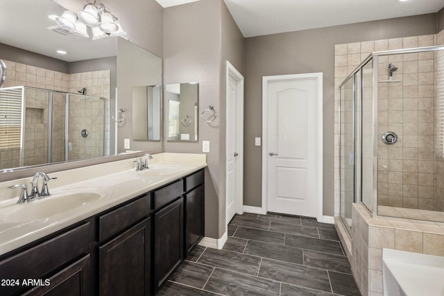 bathroom featuring a shower stall, double vanity, and baseboards
