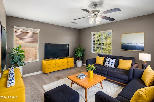 carpeted living area with baseboards and a ceiling fan