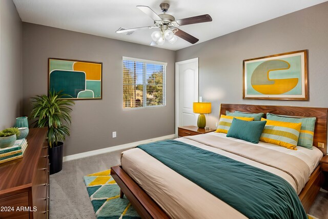 carpeted bedroom with a ceiling fan and baseboards