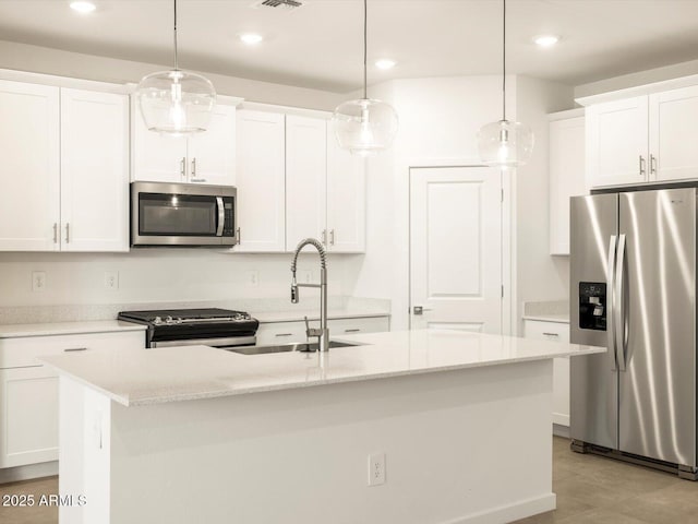 kitchen with a center island with sink, white cabinets, stainless steel appliances, and hanging light fixtures