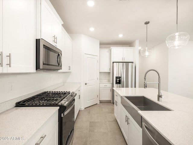 kitchen featuring light stone countertops, sink, stainless steel appliances, decorative light fixtures, and white cabinets