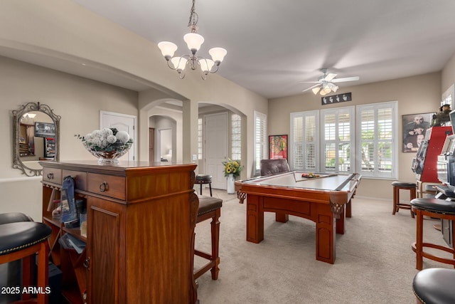 playroom with ceiling fan with notable chandelier, arched walkways, and light carpet