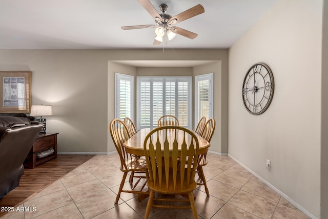 dining area featuring light tile patterned floors, baseboards, and ceiling fan