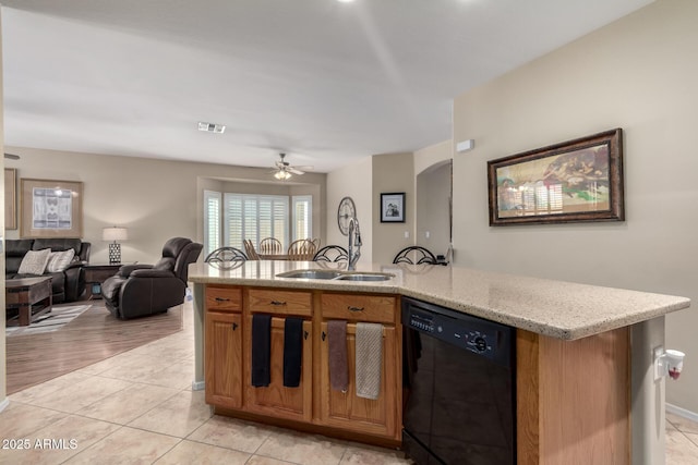 kitchen with visible vents, a sink, light stone counters, black dishwasher, and open floor plan