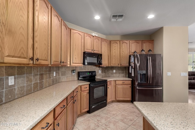 kitchen with light tile patterned floors, light stone countertops, visible vents, black appliances, and tasteful backsplash