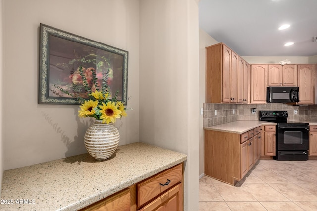 kitchen with light tile patterned floors, light stone countertops, recessed lighting, black appliances, and backsplash