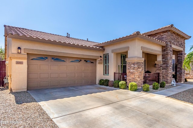 mediterranean / spanish-style home with stone siding, stucco siding, driveway, and an attached garage