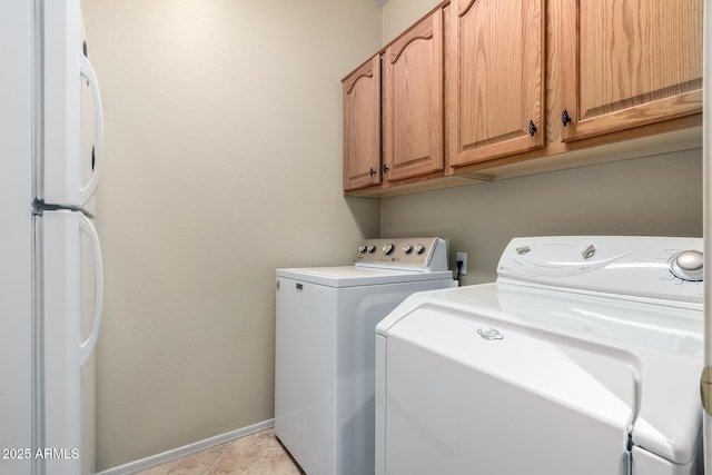 laundry room with light tile patterned floors, baseboards, cabinet space, and washing machine and clothes dryer