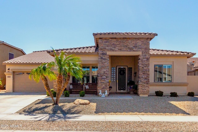 mediterranean / spanish-style house featuring a porch, a garage, stone siding, and stucco siding