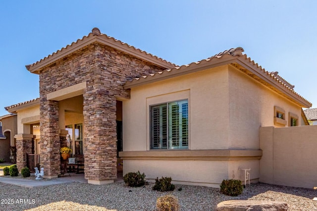 view of side of property with stucco siding and stone siding