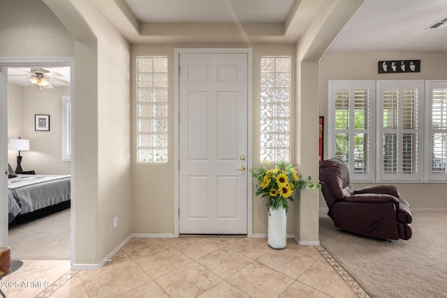 entryway with baseboards, arched walkways, and light colored carpet