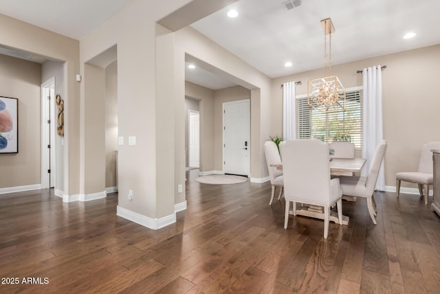 dining space with dark wood-type flooring and a chandelier